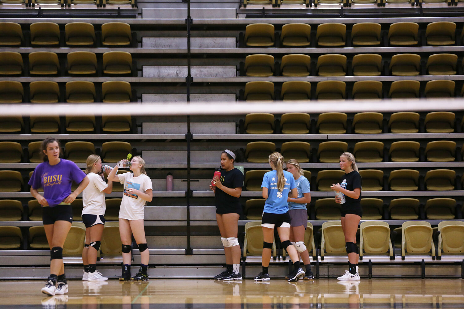 Girls return to their water bottles during a water break